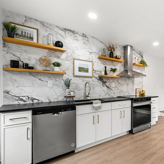 Modern kitchen with marble wall, wooden shelves, and a dining area.